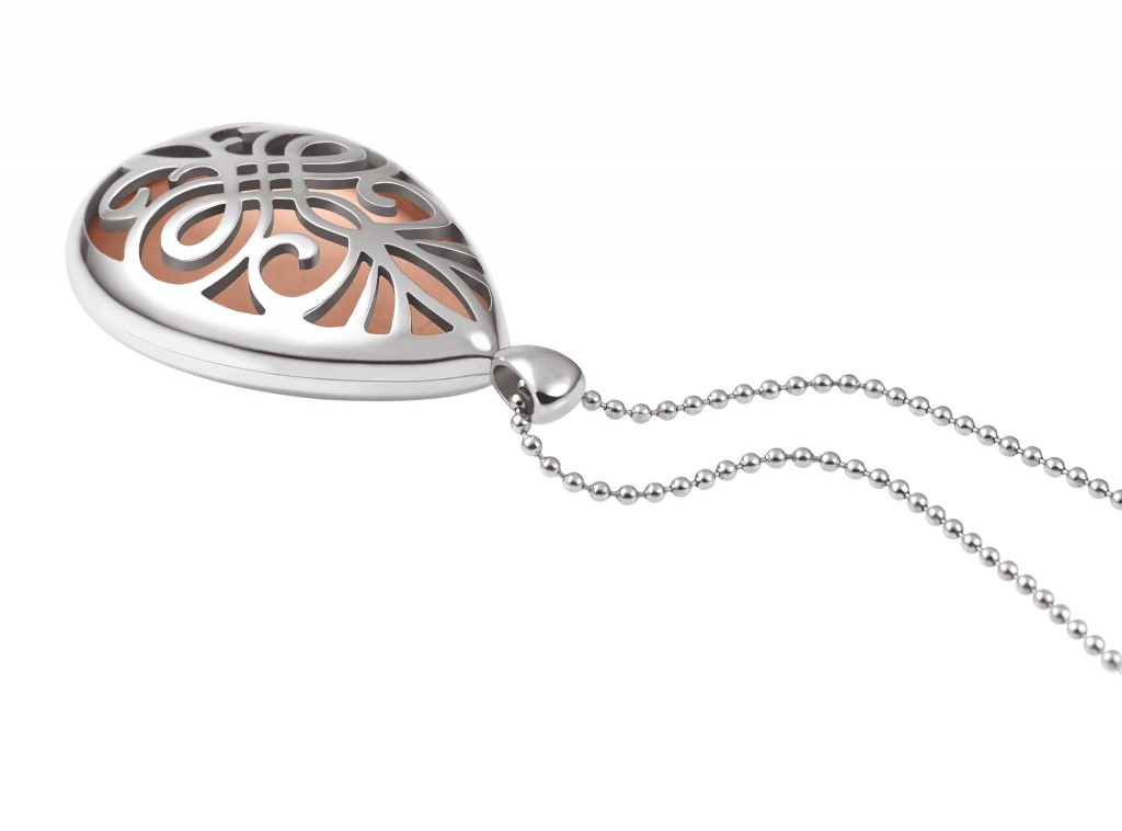 Ein silbernes Anhänger mit einem filigranen, offenen Muster und einem roséfarbenen Inneren, an einer perlenartigen Kette aufgehängt.