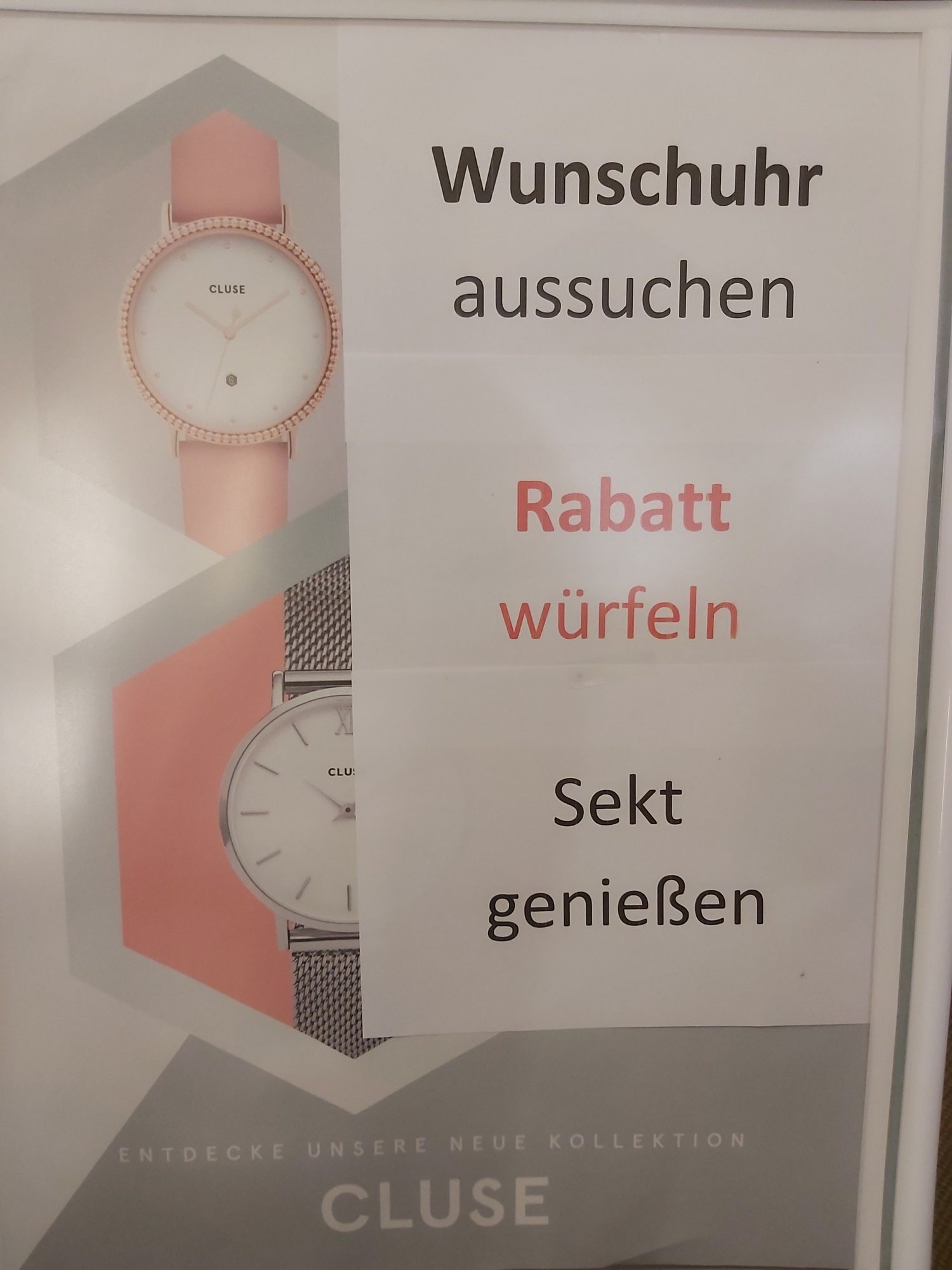 Ein Werbeplakat zeigt zwei Uhren von Cluse in verschiedenen Designs und drei Aktionen: Wunsch-uhr auswählen, Rabatt würfeln und Sekt genießen.