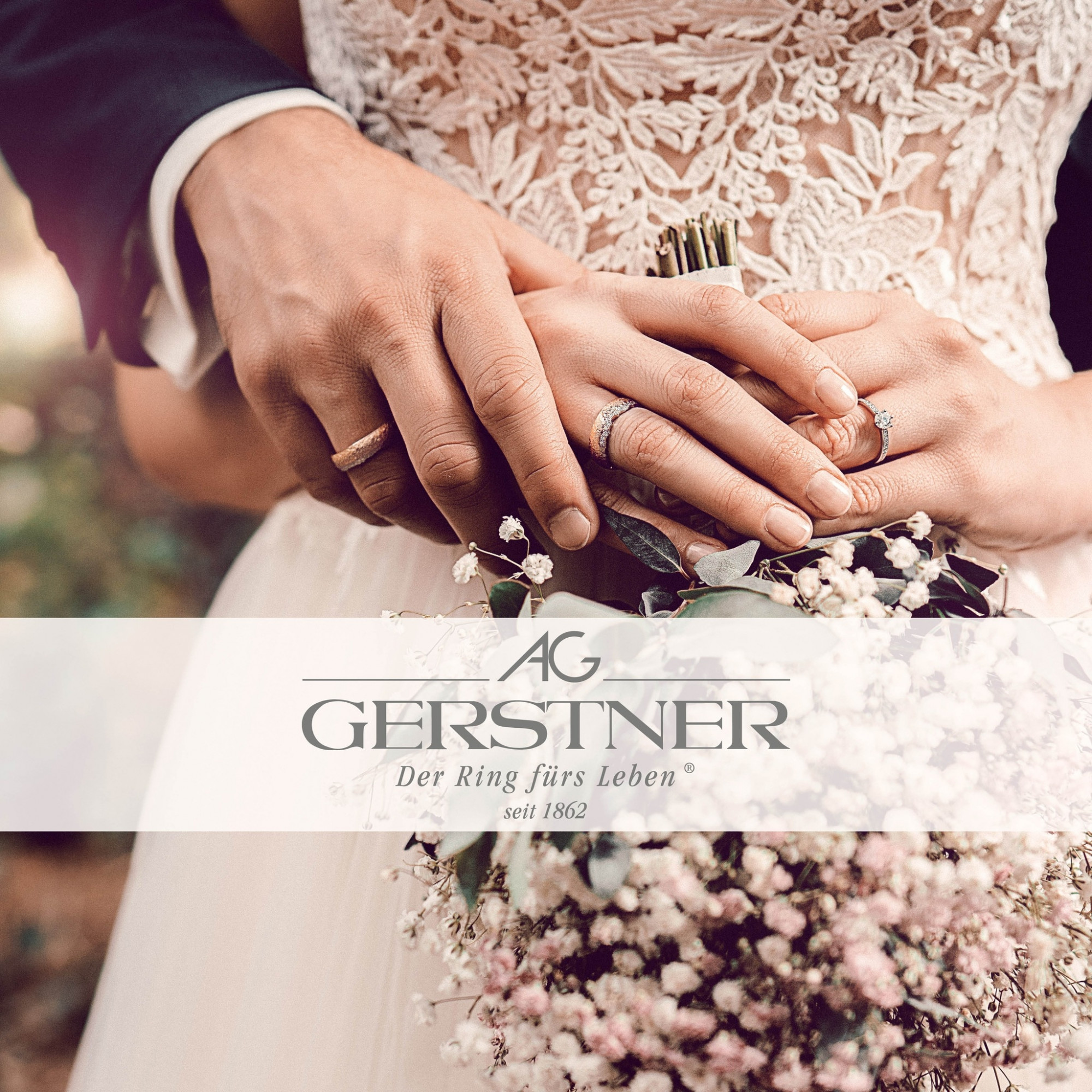 Ein Brautpaar hält sich die Hände, die mit Ringen geschmückt sind, während sie einen kleinen Blumenstrauß mit Eukalyptus und zarten Blüten halten.