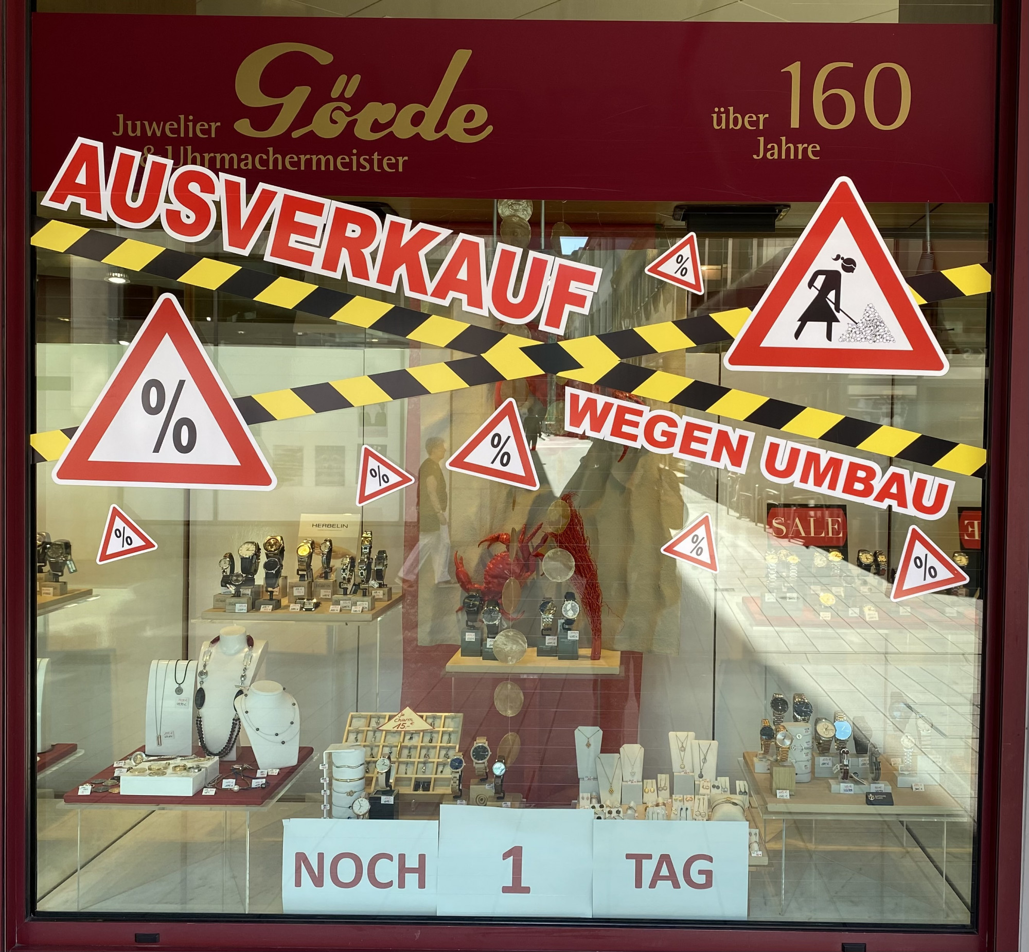 In einem Schmuckgeschäft sind große Schilder mit 
